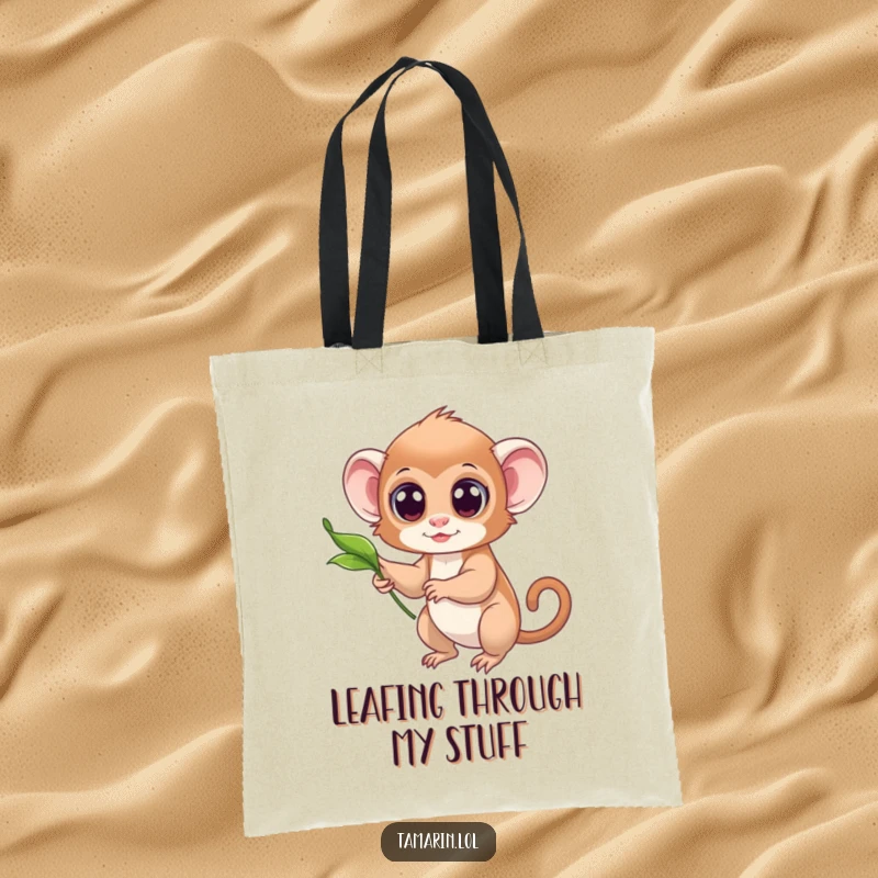 Funny tote bag depicting a small tamarin with wide, curious eyes reaching out to catch a floating leaf.